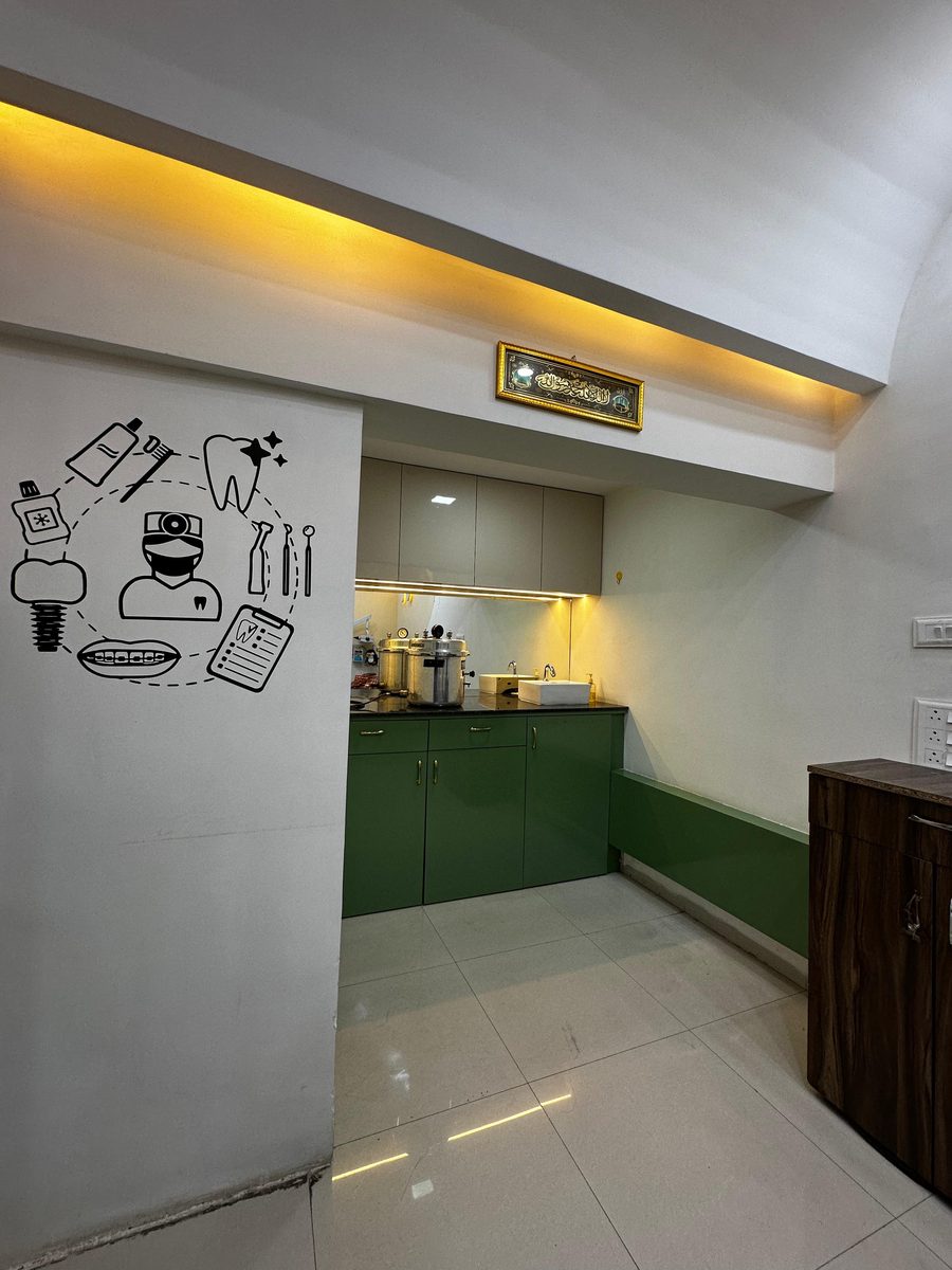 Modern treatment room with green cabinetry and warm cove lighting at Happy Tooth, Pune