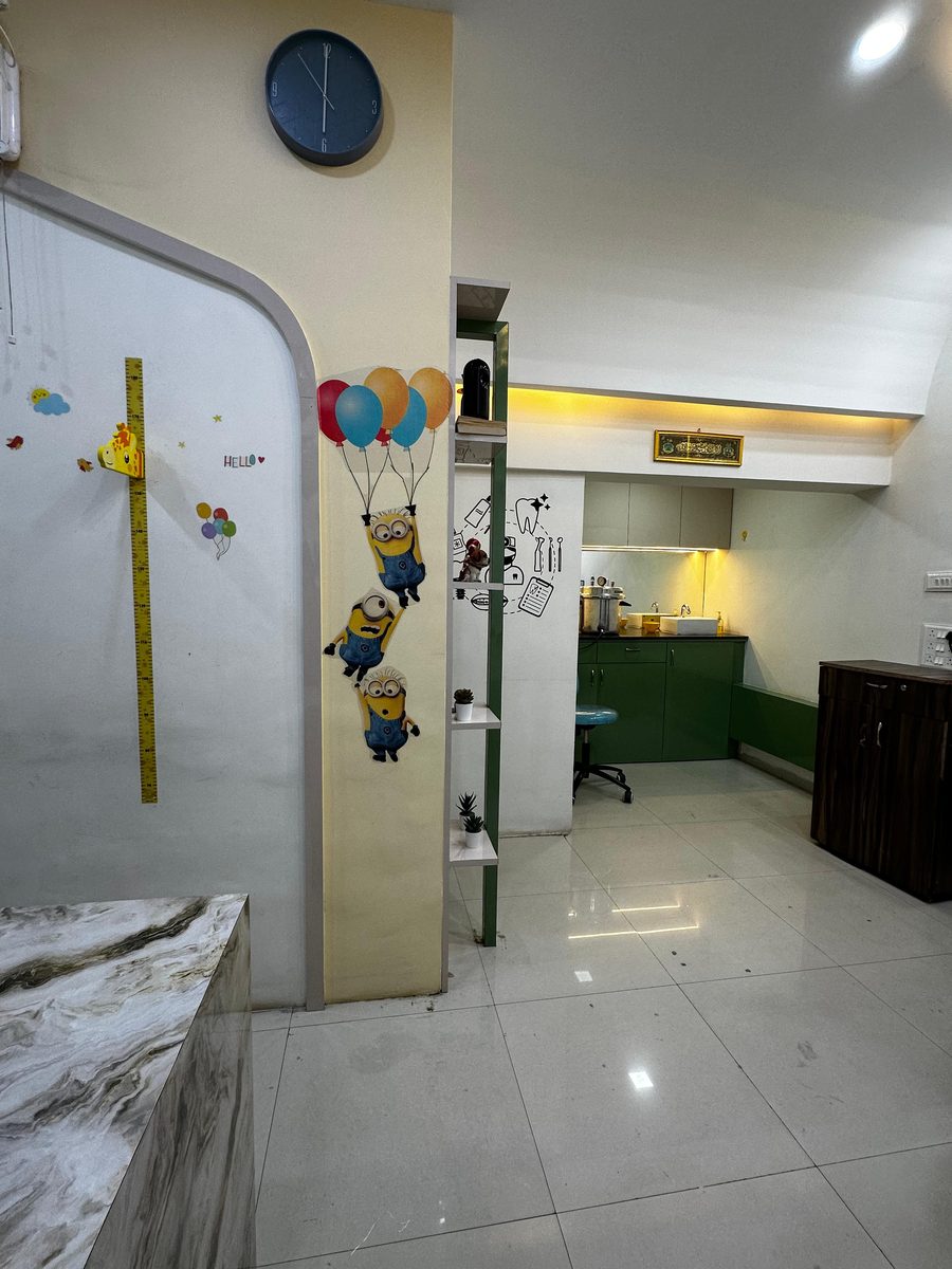 Dental operatory with warm lighting and green cabinetry at Happy Tooth, Mohamadwadi