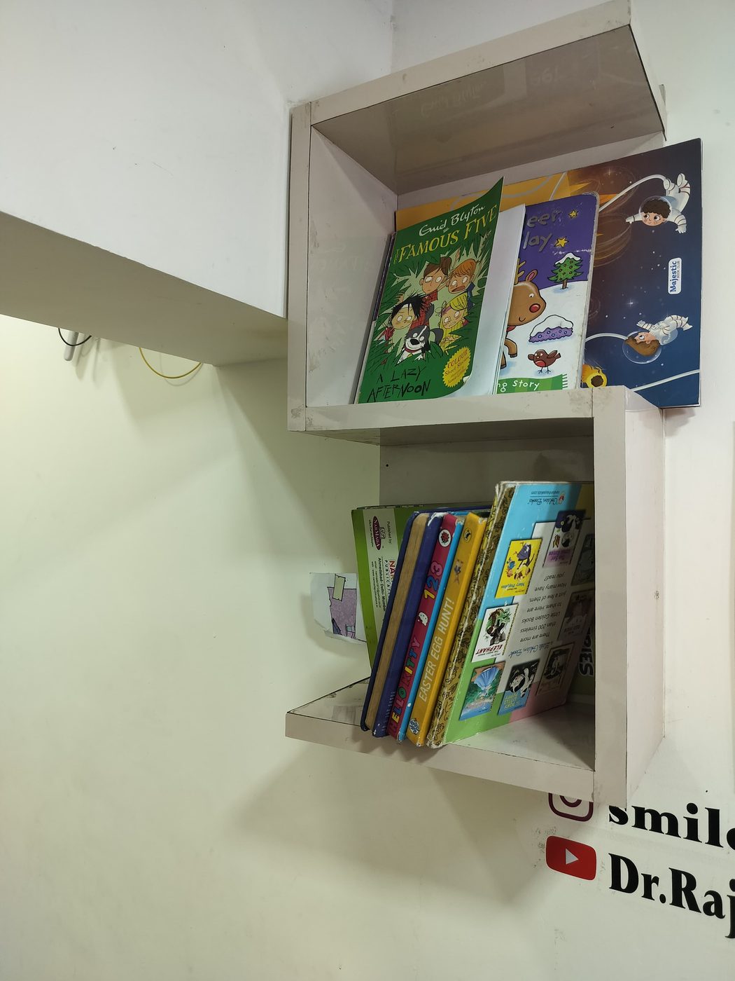 Child-friendly waiting area with a book shelf at Happy Tooth dental clinic, Pune