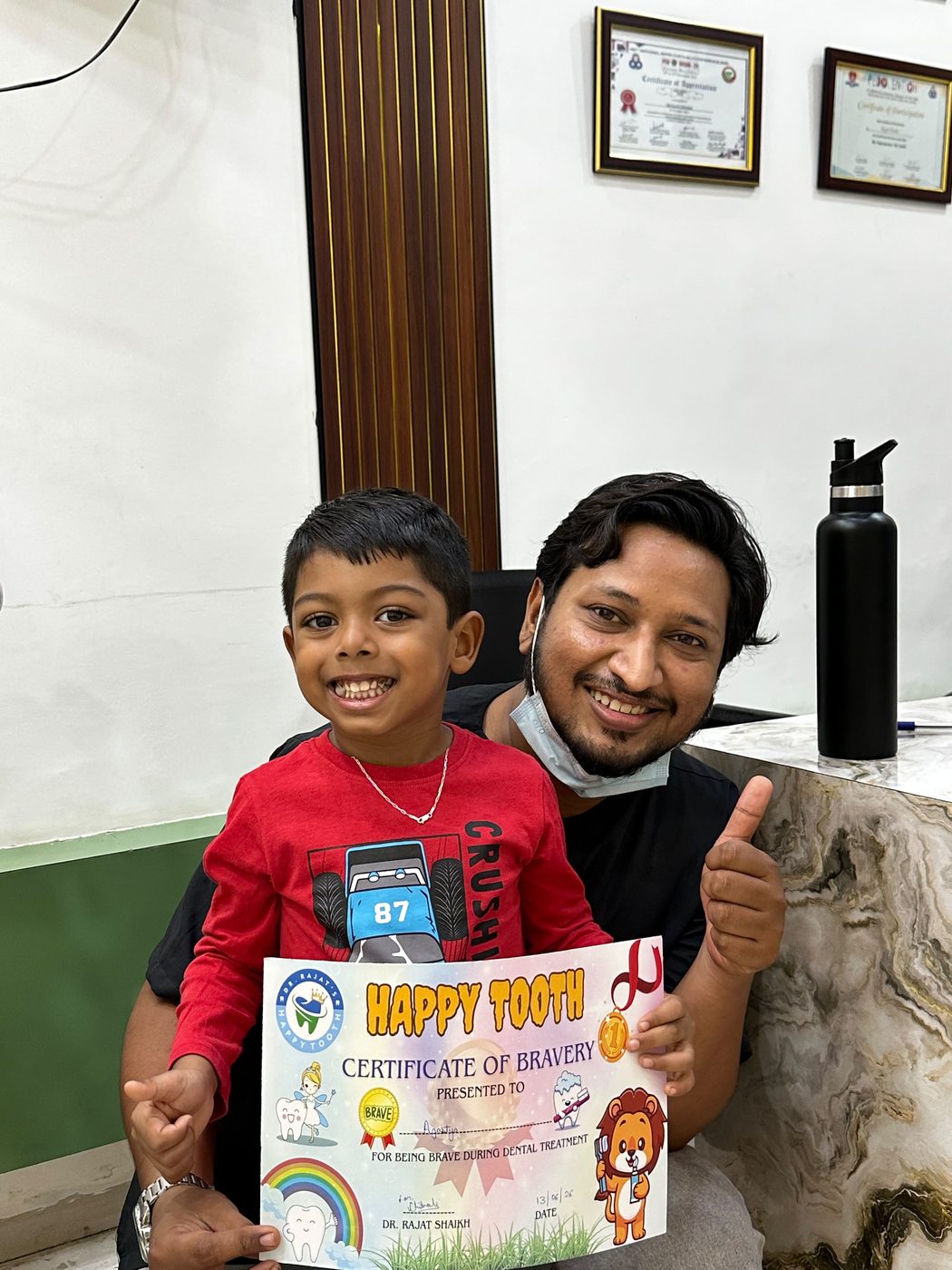 A cheerful young patient with Dr. Rajat Shaikh after a dental visit at Happy Tooth, Pune