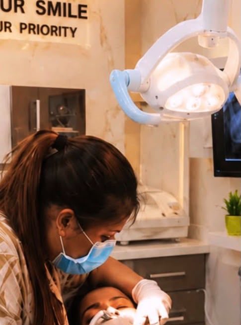 Dentist comforting a child during treatment under the "Your Smile Our Priority" sign at Happy Tooth, Mohamadwadi